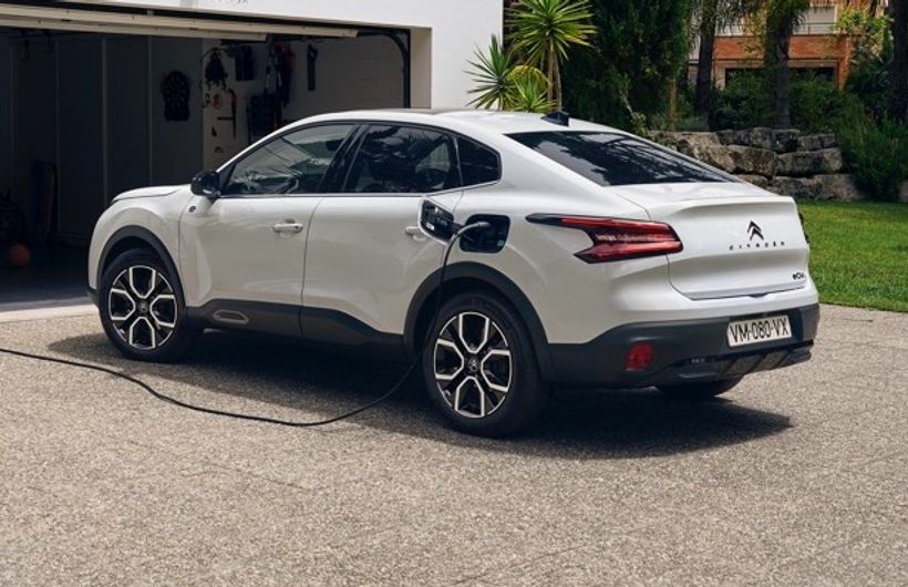 White Citroen e-C4X rear side profile view while charging